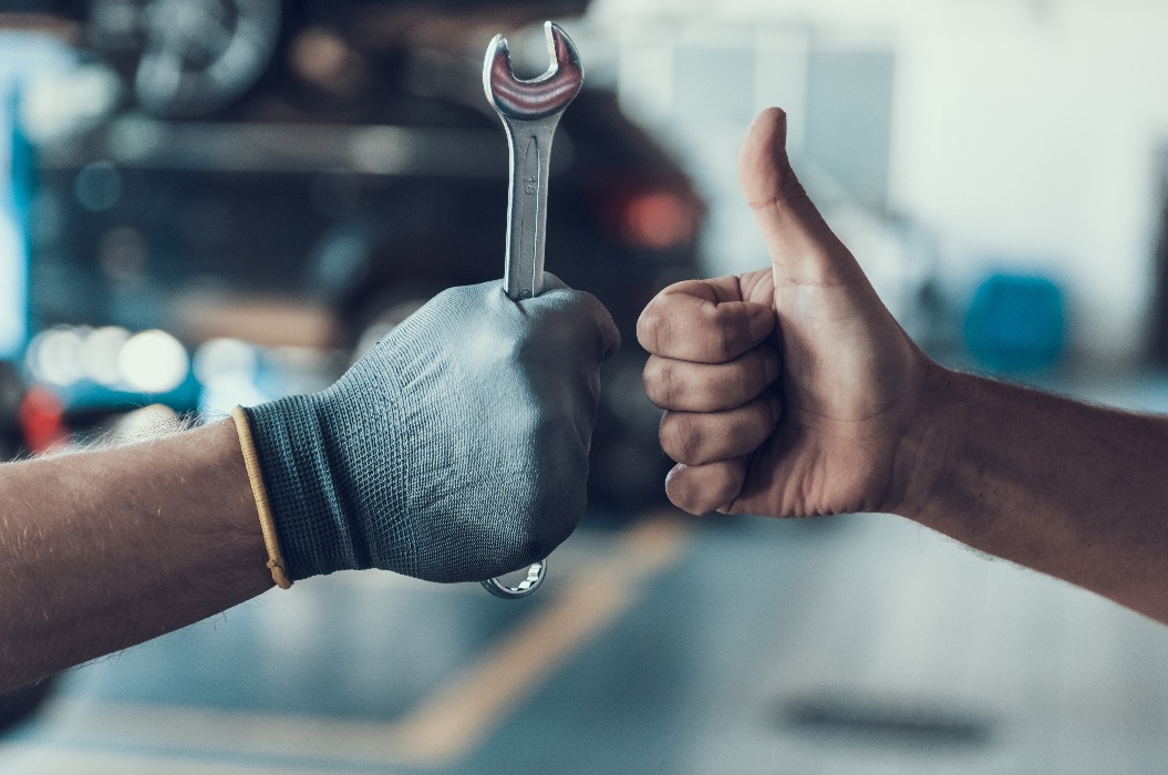 6193015 Nahaufnahme Daumen hoch und Mechanikerhand mit Werkzeug